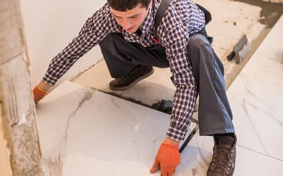 Construction worker tiler is tiling, ceramic tile floor adhesive. Laying Ceramic Tiles.